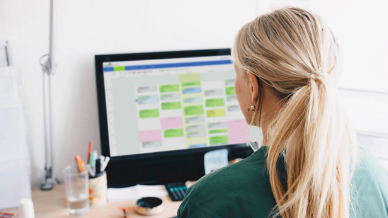 Woman looking at a computer screen with an appointment schedule pulled up