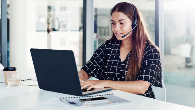 Young women wearing headset at laptop