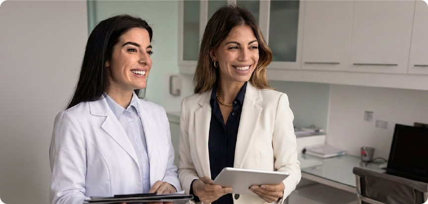Two optometrists smiling with one holding an ipad.