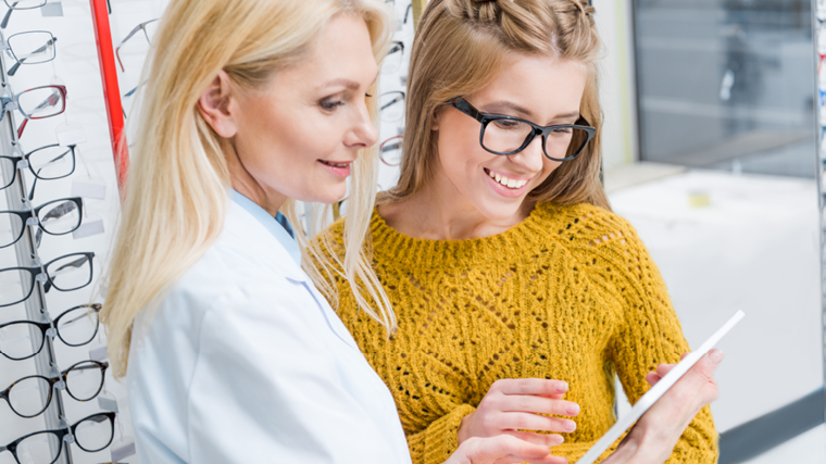 Doctor and patient in optical dispensary looking at tablet