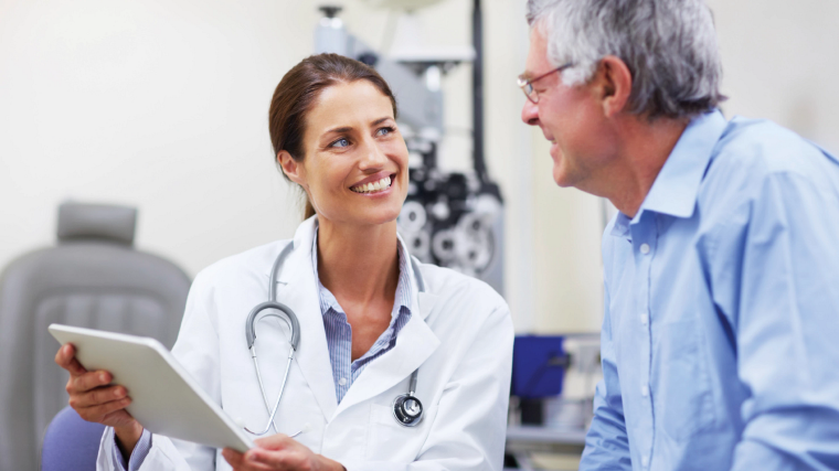 Smiling provider talking to patient holding an iPad