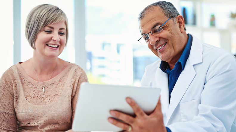 Doctor and patient smiling at a tablet