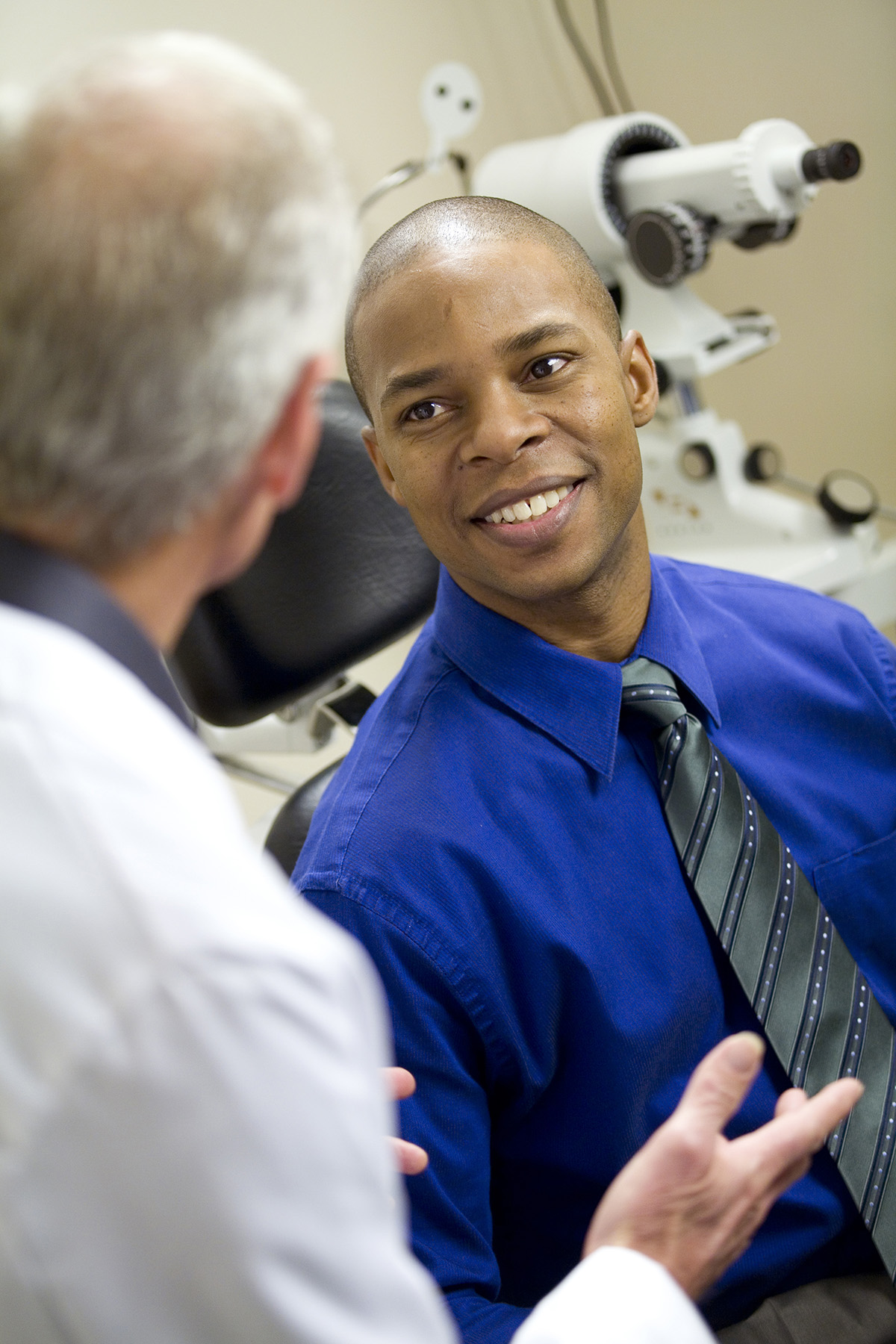 eye doctor and a man in blue shirt consult
