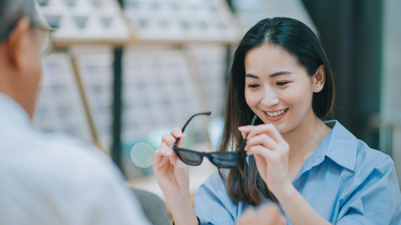 Doctor with patient trying on sunglasses