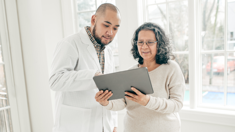 Doctor and patient in an office looking at a tablet together